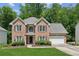 Charming two-story brick home featuring a well-manicured lawn and a two-car garage at 610 Golden Meadows Ln, Suwanee, GA 30024