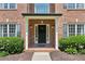 Inviting brick front porch with columns and black front door at 610 Golden Meadows Ln, Suwanee, GA 30024