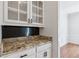 Elegant kitchen area showcasing granite countertops, white cabinets, and glass-front display cabinets at 610 Golden Meadows Ln, Suwanee, GA 30024