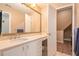 Bathroom with a large mirror over a marble vanity, cabinets, and an adjacent room at 1640 Settindown Dr, Roswell, GA 30075