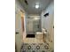 Clean bathroom featuring a tiled walk-in shower with a sliding glass door and decorative tiled floors at 1640 Settindown Dr, Roswell, GA 30075