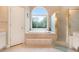 Bathroom featuring a large arched window over soaking tub, and a glass enclosed shower stall at 1640 Settindown Dr, Roswell, GA 30075