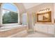 Bathroom featuring a large arched window over soaking tub, shower stall, and a large mirror at 1640 Settindown Dr, Roswell, GA 30075