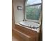 Bathroom featuring a large soaking tub and big window with lake view at 1640 Settindown Dr, Roswell, GA 30075