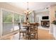 Sunlit dining area adjacent to the living room, featuring a fireplace and large windows with backyard views at 1640 Settindown Dr, Roswell, GA 30075