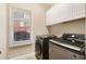 Functional laundry room with modern washer and dryer, plus storage cabinets for household essentials at 1640 Settindown Dr, Roswell, GA 30075