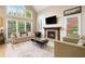 Cozy living room with a fireplace, large windows providing natural light, and comfortable seating at 1640 Settindown Dr, Roswell, GA 30075