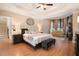 Serene primary bedroom with a tray ceiling, plush bedding, and a seating area by a sun-filled bay window at 1640 Settindown Dr, Roswell, GA 30075