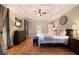 Spacious main bedroom with a tray ceiling, ceiling fan, hardwood floors, and neutral walls at 1640 Settindown Dr, Roswell, GA 30075