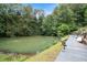 Picturesque pond surrounded by lush landscaping and a wooden dock at 1640 Settindown Dr, Roswell, GA 30075
