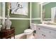 Stylish powder room with decorative green walls, and a white vanity at 1640 Settindown Dr, Roswell, GA 30075