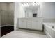 Bathroom featuring a double vanity, tiled floors, and a soaking tub at 2464 Georgetown Ave, Atlanta, GA 30345