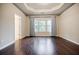 A sunlit bedroom featuring tray ceilings, hardwood floors and large windows at 2464 Georgetown Ave, Atlanta, GA 30345