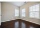 An empty bedroom with three windows and hardwood floors at 2464 Georgetown Ave, Atlanta, GA 30345