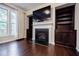 Living room with fireplace, built-in shelving and large windows with hardwood floors at 2464 Georgetown Ave, Atlanta, GA 30345