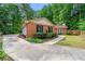 Exterior view of a charming brick home with a long driveway, complemented by lush landscaping at 2991 Black Bear Se Dr, Marietta, GA 30067
