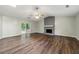 Spacious living room with hardwood floors, gray brick fireplace, fan and sliding door to outside at 2991 Black Bear Se Dr, Marietta, GA 30067