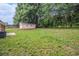 Spacious backyard featuring lush greenery, a detached garage, and mature trees at 35 Riverbend Dr, Covington, GA 30014