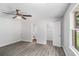 Bedroom features gray wood-look floors, closet, ceiling fan and bathroom access at 35 Riverbend Dr, Covington, GA 30014
