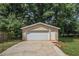 Detached garage with ample storage, enhanced by lush greenery, creates curb appeal at 35 Riverbend Dr, Covington, GA 30014