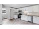 Updated kitchen with white cabinets, stainless steel appliances, granite countertops, and new gray vinyl floors at 35 Riverbend Dr, Covington, GA 30014