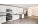Modern kitchen featuring white cabinets, granite countertops, and stainless steel appliances open to the living room at 35 Riverbend Dr, Covington, GA 30014