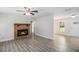 Inviting living room with stone fireplace and gray wood-look floors under a ceiling fan at 35 Riverbend Dr, Covington, GA 30014
