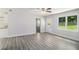 Open living room featuring gray flooring, large windows, a white door to outside, and a peek into the kitchen at 35 Riverbend Dr, Covington, GA 30014
