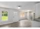 Open-concept space with gray floors, leading to a kitchen area with white cabinets, and a bright entryway at 35 Riverbend Dr, Covington, GA 30014