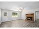 Cozy living room showcasing a stone fireplace, gray flooring, a ceiling fan, and plenty of natural light at 35 Riverbend Dr, Covington, GA 30014