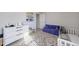 Bedroom room with white crib, sofa, geometric patterned rug, and dresser at 807 Parker Pass, Peachtree City, GA 30269