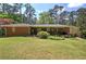 A home's brick exterior and covered patio provide a cozy outdoor space surrounded by a lush green lawn and trees at 3156 Pope Rd, Douglasville, GA 30135