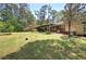 Large, shady backyard featuring a covered patio and mature landscaping, ideal for relaxation at 3156 Pope Rd, Douglasville, GA 30135