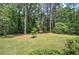A serene view of a lush backyard with mature trees and an outbuilding at 3156 Pope Rd, Douglasville, GA 30135