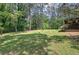 Expansive backyard featuring a large lawn and mature trees, providing a serene and private outdoor space at 3156 Pope Rd, Douglasville, GA 30135