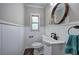 Cozy powder room with white wainscoting and a round mirror at 3156 Pope Rd, Douglasville, GA 30135