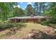 A home with a brick exterior and well-maintained lawn nestled amongst mature trees at 3156 Pope Rd, Douglasville, GA 30135