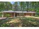 Charming brick home with a well-maintained lawn and mature trees providing shade at 3156 Pope Rd, Douglasville, GA 30135