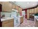 Bright kitchen featuring light oak cabinets, brick floors, and white appliances at 3156 Pope Rd, Douglasville, GA 30135