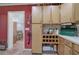 Rustic kitchen design with wood cabinets, brick floors, and red accent wall at 3156 Pope Rd, Douglasville, GA 30135