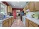 Galley kitchen with brick floors, oak cabinets, and a view into the living room at 3156 Pope Rd, Douglasville, GA 30135