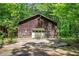 An outbuilding with garage door tucked away in a wooded area at 3156 Pope Rd, Douglasville, GA 30135