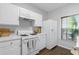 Well-lit kitchen features white appliances, subway tile backsplash, hardwood floors, and natural light at 3754 Berkeley Xing, Duluth, GA 30096