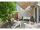 Charming patio with white Adirondack chairs, bench, and awning, surrounded by lush greenery and landscaping at 3754 Berkeley Xing, Duluth, GA 30096