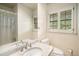 Bright bathroom featuring a granite countertop, mirror, toilet, and window with shutters at 2556 Defoors Ferry Nw Rd, Atlanta, GA 30318