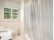 Bathroom features white tile and shower with clear curtain at 2559 Defoors Ferry Nw Rd, Atlanta, GA 30318