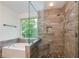 Bright bathroom featuring a bathtub and glass shower with river rock and wooden wall tiles at 3260 Ridgefair Dr, Cumming, GA 30040