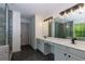 Bright bathroom featuring a double vanity, granite countertops, a glass shower, and wood-look floors at 3260 Ridgefair Dr, Cumming, GA 30040