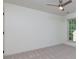 A carpeted bedroom with a ceiling fan, white walls, and a large window at 3260 Ridgefair Dr, Cumming, GA 30040