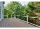 Expansive wooden deck with black railings provides views of surrounding trees and greenery at 3260 Ridgefair Dr, Cumming, GA 30040
